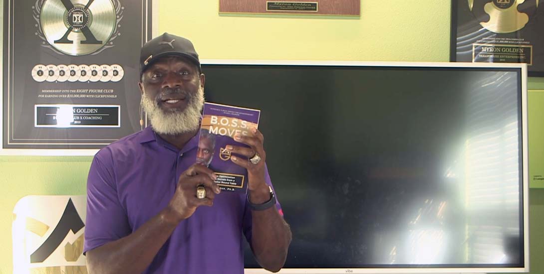Myron Golden holding his new book BOSS Moves